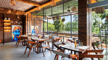 Cosy interior of a contemporary restaurant with wooden furniture and a unique blue sky ceiling mural.