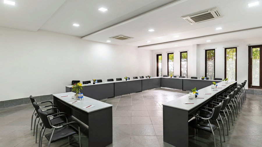 A meeting room configured in a U-shape layout with black desks and chairs | Anandam Jungle Retreat Resort, Udaipur