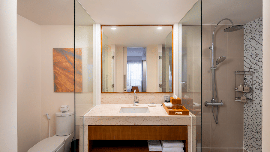 Penthouse bathroom at Central Mansions, Phnom Penh with a walk in shower, vanity, toilet, and modern amenities.