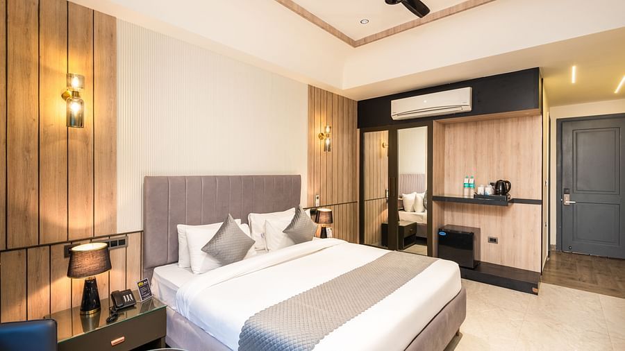 Deluxe Room at DLS Divine River Resort and  Spa featuring a  king bed , side table, warm lighting and other amenities.