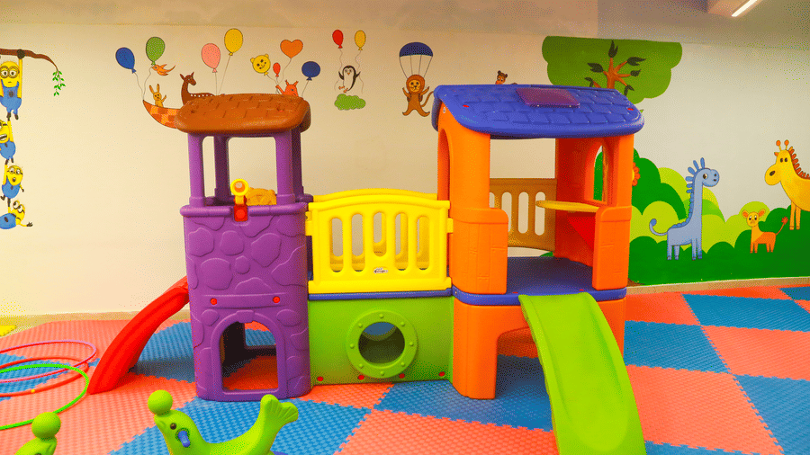 A close-up of a plastic indoor play structure with a slide and tunnel for children at DNC Shevaroys Resort & Spa.