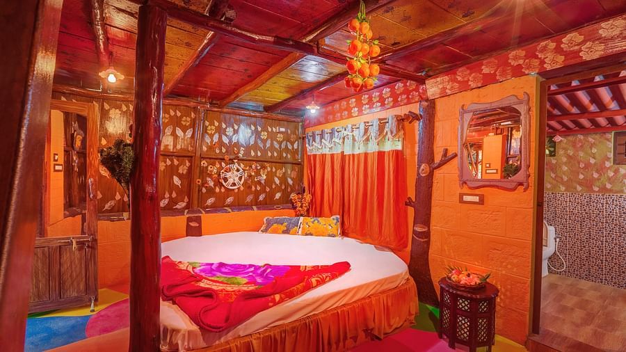 A ambiently lit room with a large bed in family wooden cottage - Evergreen County