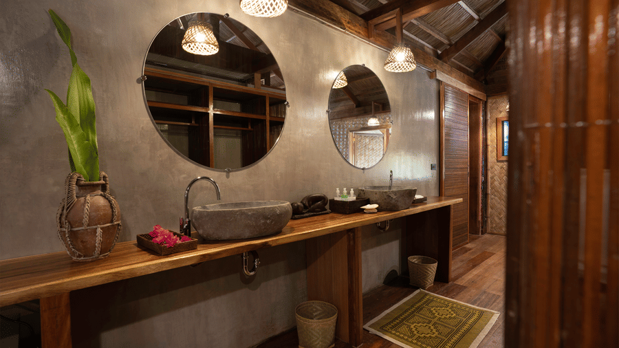 A bathroom with mirrors, two stone sinks, and lights at Flower Island Resort.