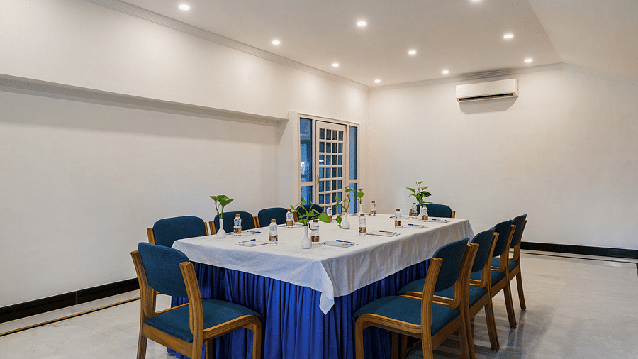 An overview of raj darshan conference with a large table and blue chairs in view - Hotel Rajdarshan, Udaipur.