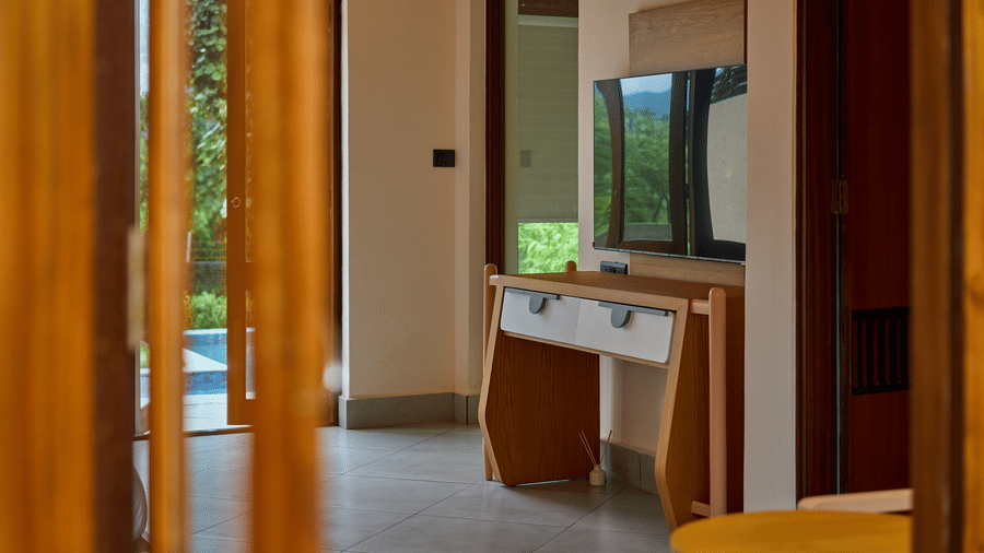 Wooden door frames featuring a room with a television and a wooden table at Hotel Sonar Bangla, Ajodhya Hills.
