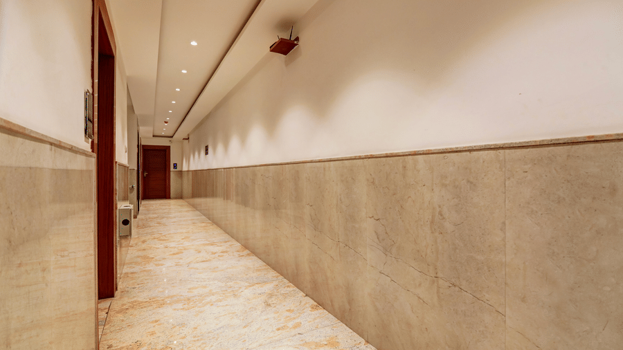 Long, clean hotel hallway with marble flooring and recessed lighting - Hotel Velocity