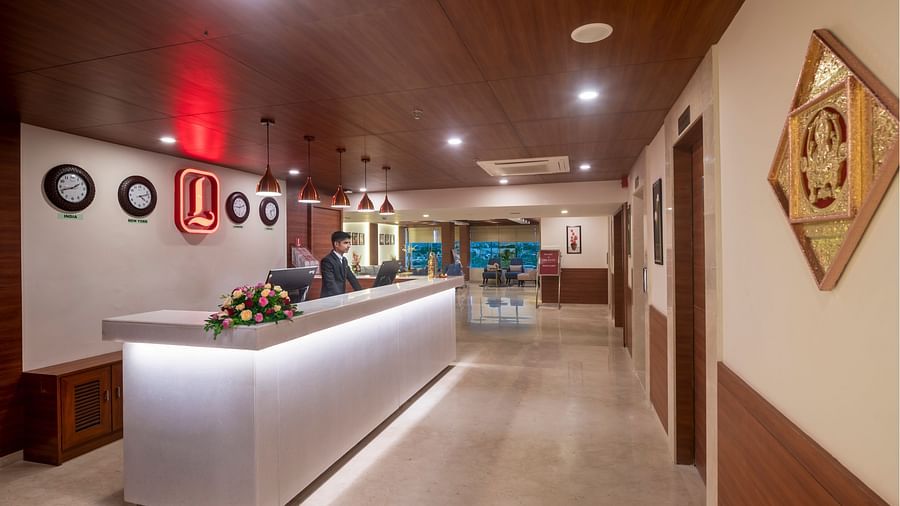 Reception area with minimalist design and clocks on the wall indicating time zones - Lords Eco Inn Shapar Rajkot