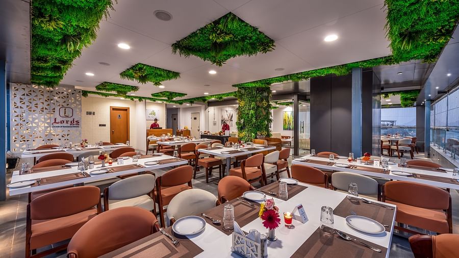 A spacious lime tree rooftop restaurant interior with earth-toned seating and lush ceiling decor.