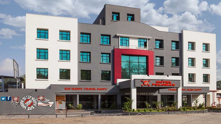 facade image of our hotel taken on a bright sunny day with cloudy blue skies in the background - Max Hotel Jabalpur