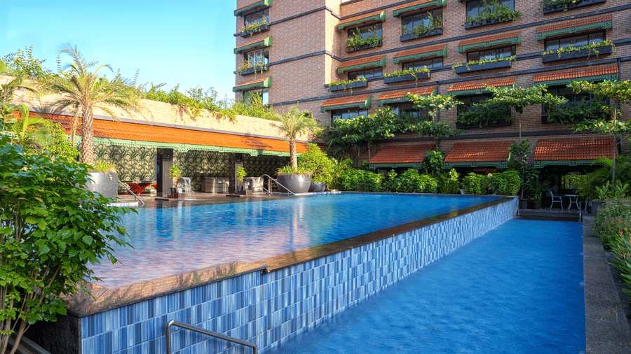 Exterior view of MAYFAIR Bay Resort, Paradeep's building with dark cladding, overlooking a rectangular swimming pool.