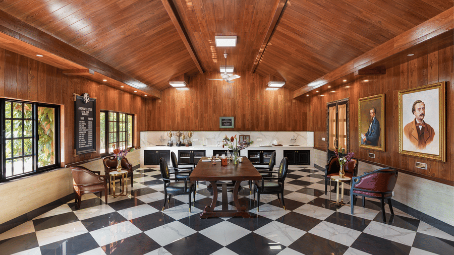 Elegant wooden-ceiling lounge with black and white checkered floor at Mayfair Manor, Jungpana.