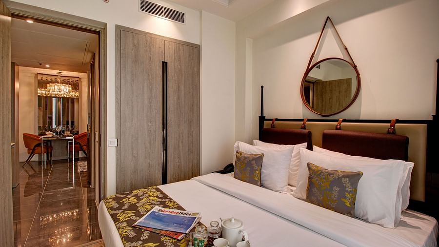 A kind bed with many pillows and a bed runner on it inside Deluxe Suite at Rhythm Gurgaon