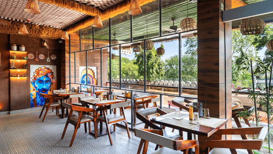 Cosy interior of a contemporary restaurant with wooden furniture and a unique blue sky ceiling mural.