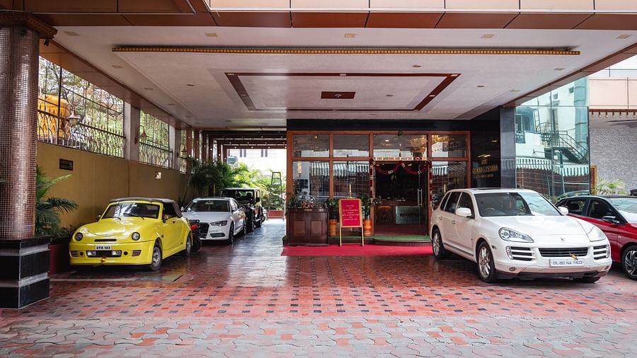 image of the entrance of The Grand Krishna Rooms featuring a few cars parked in front of it
