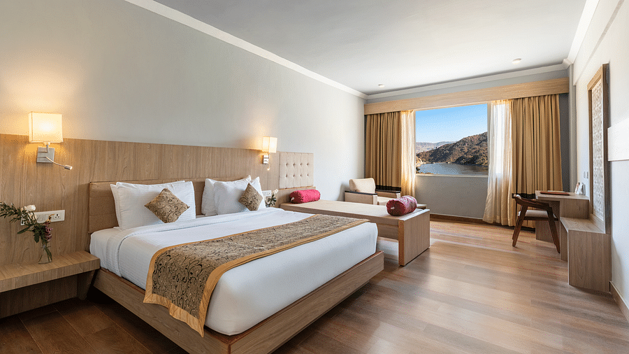 A wide angle shot of a room with a large bed neatly arranged with a patterned runner on it - Via Lakhela Resort & Spa, Kumbhalgarh