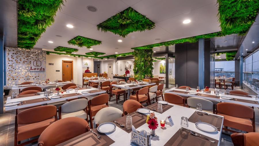 A spacious lime tree rooftop restaurant interior with earth-toned seating and lush ceiling decor.