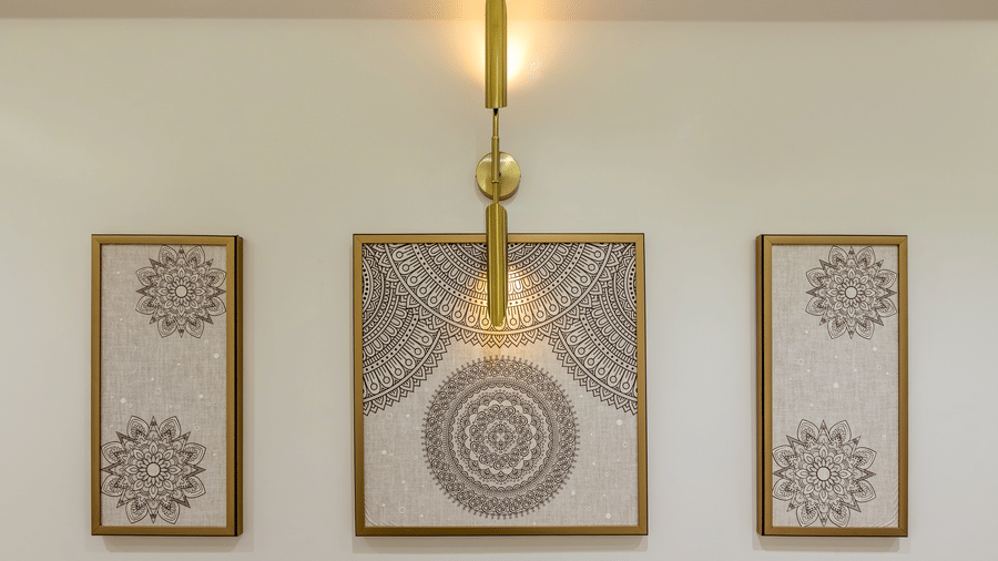 Decorative wall art display at Lords Inn Sangam, Bhopal featuring three framed mandala artworks with a brass wall sconce light above.