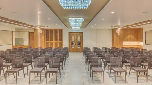 Ballroom at VITS Select Nashik Hotels & Resorts featuring a classroom seating arrangement with chairs lined up under warm lighting