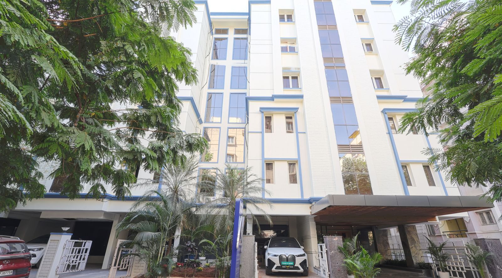 The exterior view of the Monday Hotels HITEC City, Hyderabad building surrounded by greenery.