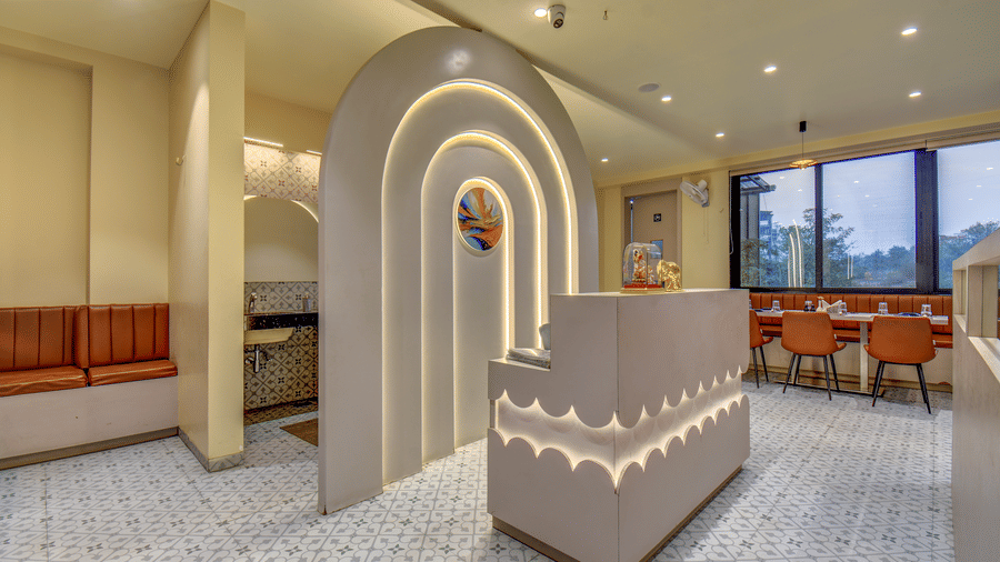 Hotel restaurant with an arched feature wall, soft lighting, and neatly arranged dining tables at VITS Select Nashik Hotels & Resorts.