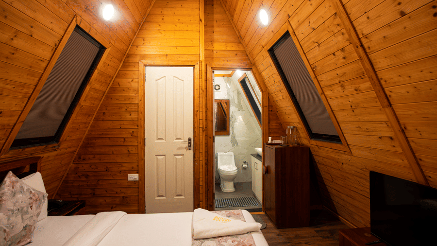 Villa bedroom featuring a triangular skylight and wooden ceiling at Hotel Sonar Bangla, Taki.