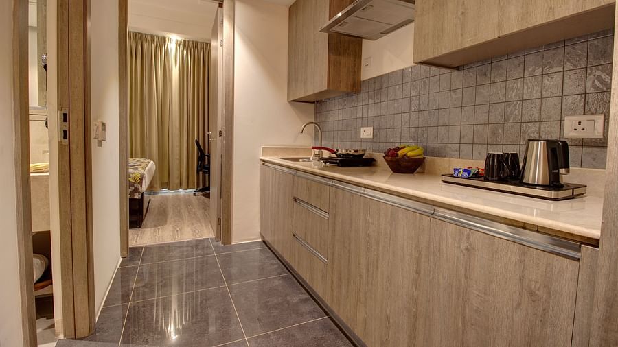 Overview of the Kitchenette with an electric stove and a kettle kept on the counter inside the deluxe room - Rhythm Gurugram