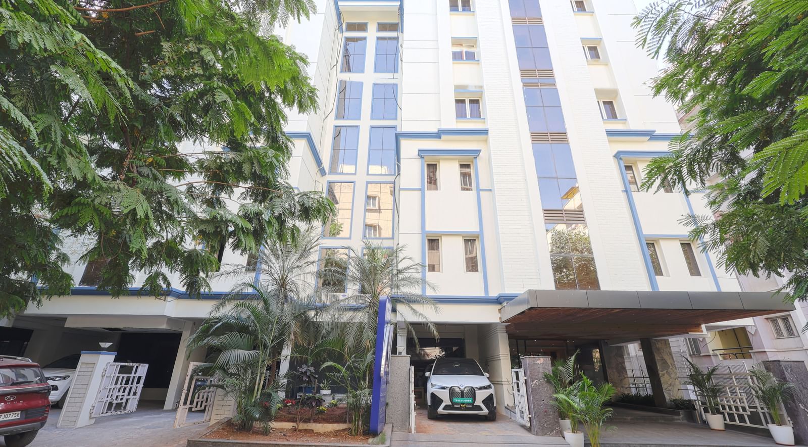 The exterior view of the Monday Hotels HITEC City, Hyderabad building surrounded by greenery.