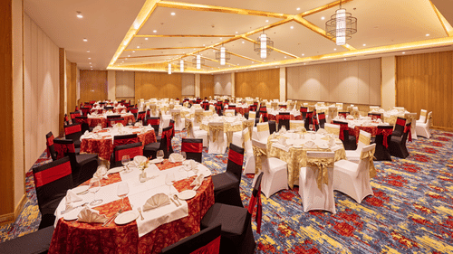Banquet hall setup with red and white chair covers and decorative lighting - Royal Tulip, Chitwan