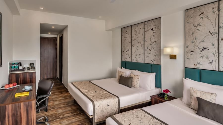 Guest room at Voyage Milestone Hotel and Banquet with twin beds and wooden flooring.