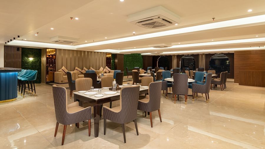 A shot of a restaurant at with chairs and tables and warm lighting - DLS Grand Luxotica, Dehradun