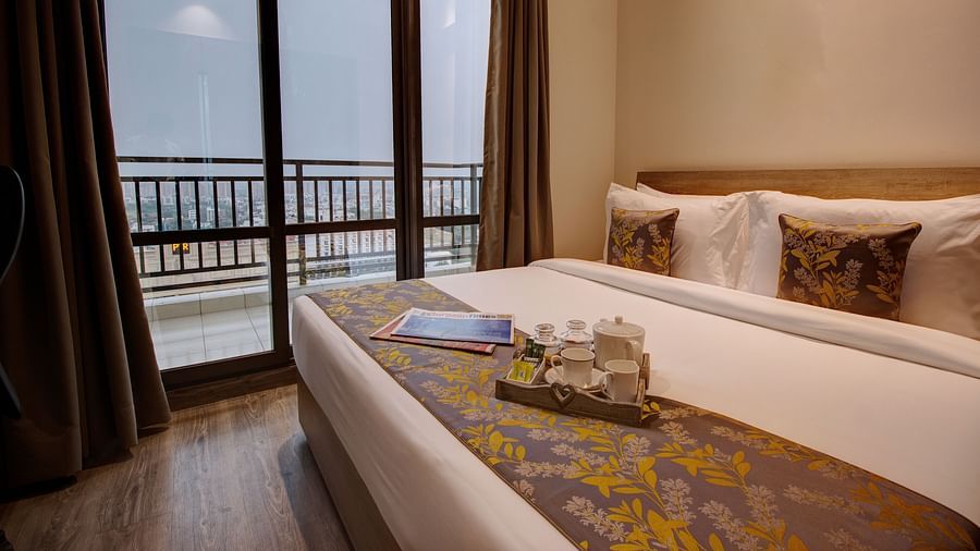 a king bed with pillows and bed runner inside the Two bedroom Executive Suite - Rhythm Gurugram