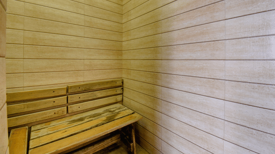Wooden steam room interior with bench seating and warm ambient lighting at VITS Lonavala.
