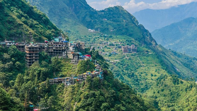 A town situated on the slopes on a mountain covered with lush greenery