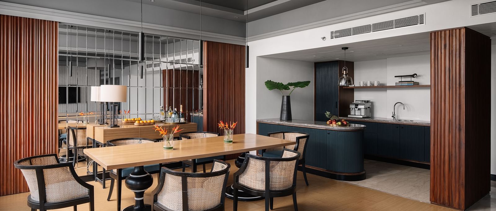 A seating area with a table and chair around it and a kitchen counter in the corner at The Raintree Hotel, St. Mary's Road.