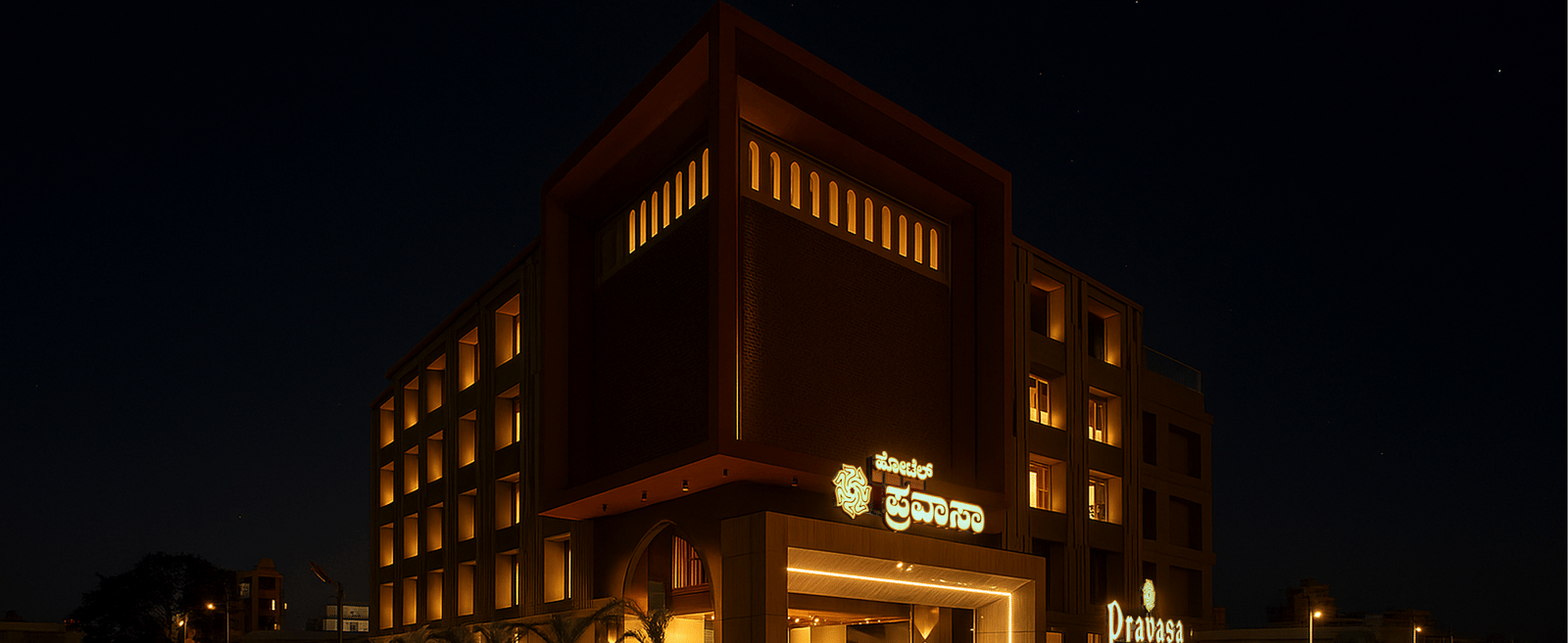  Exterior view of Pravasa Hotel at night with illuminated windows | Pravasa Hotel, Vijayapura