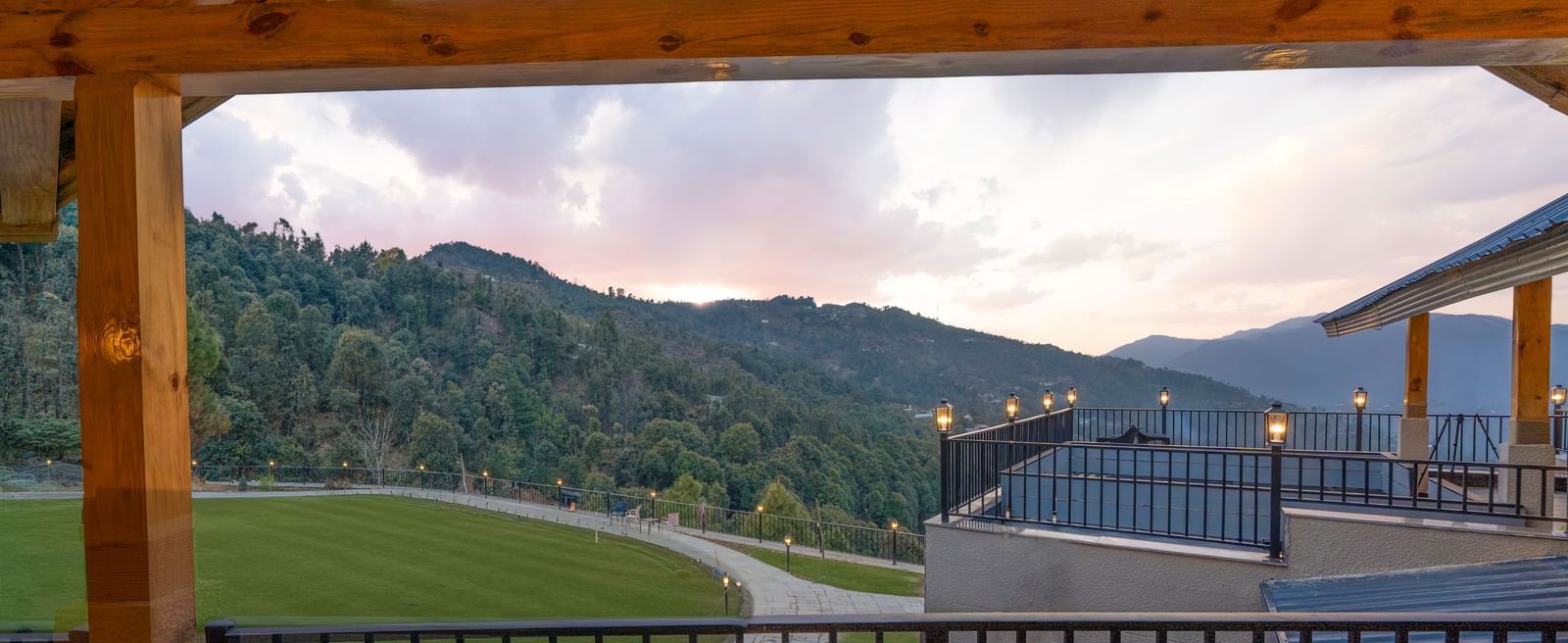 A view from a balcony reveals forested hills against a cloudy sky at The Chamomile Estate.