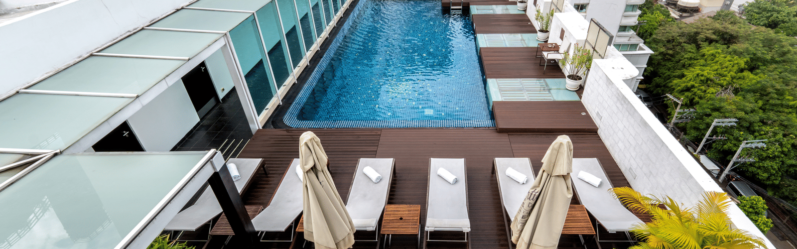 Aerial view of the rooftop swimming pool with loungers in view - Night Hotel Bangkok - one of the best Guest-Friendly Hotels Near Soi Cowboy, Bangkok.