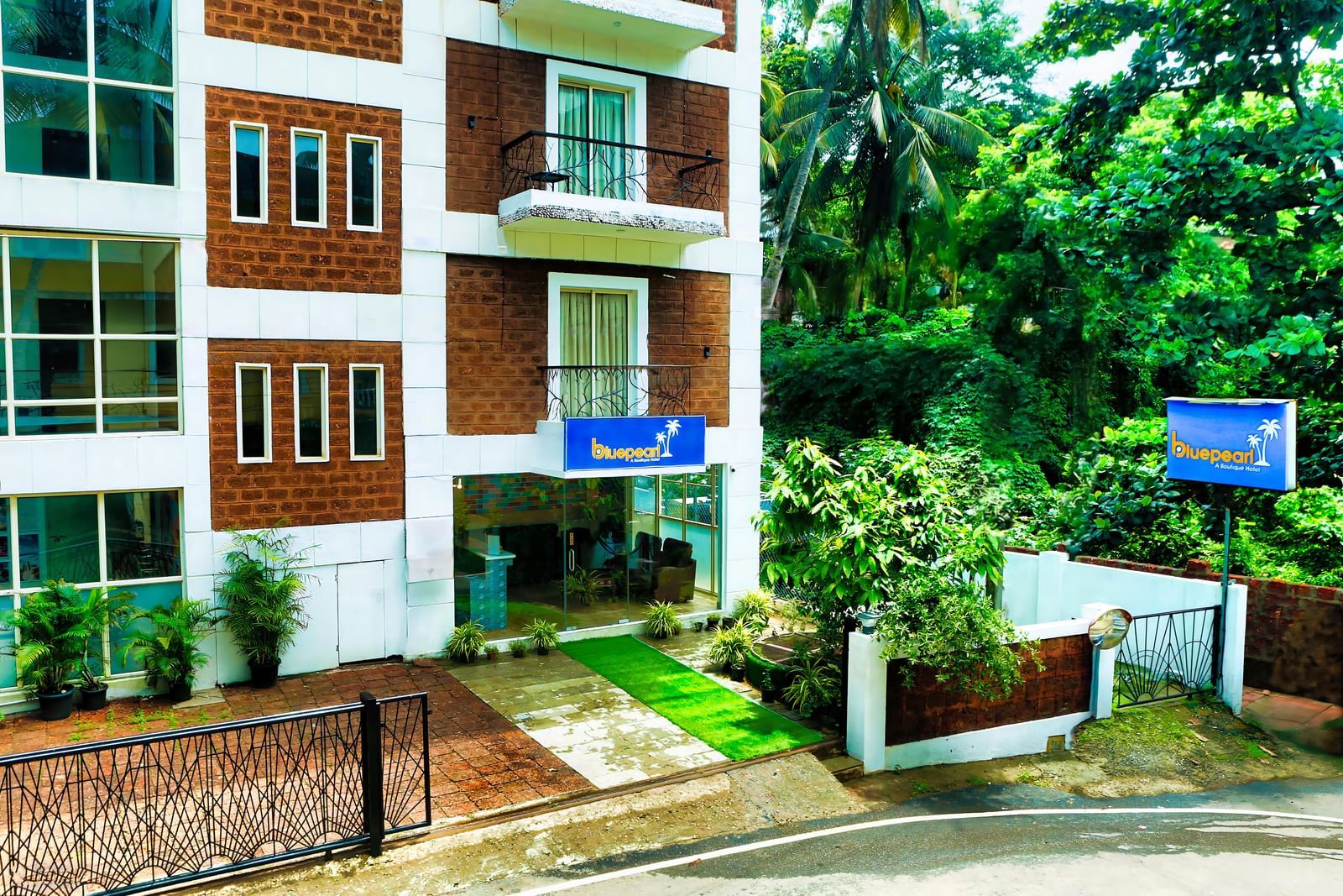 Front view of Daksh Elite Hotel, Goa with greenery and a clean, inviting entrance.