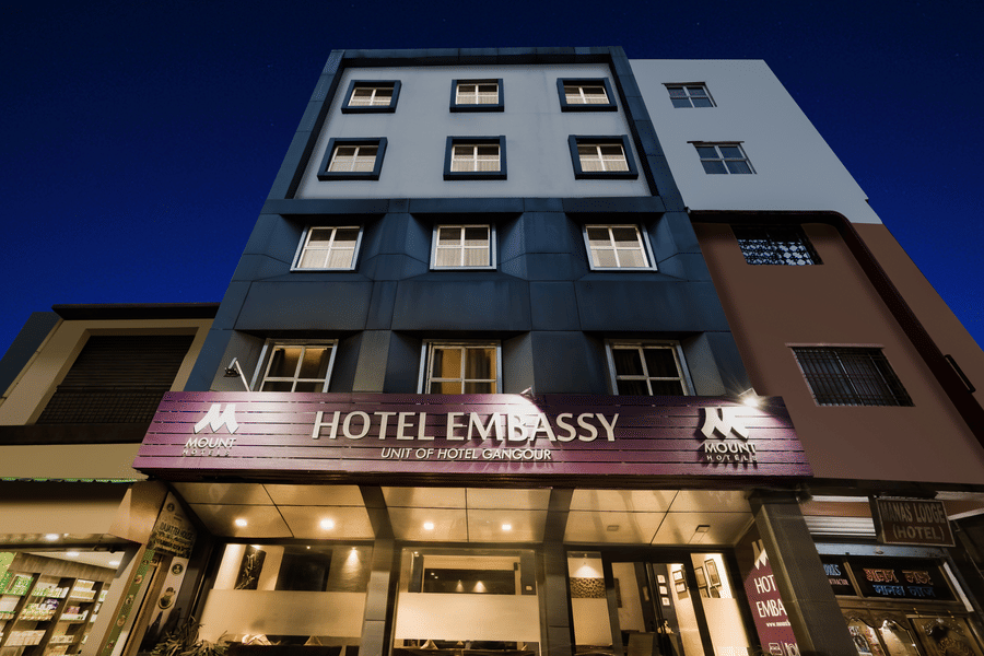 Mount Embassy Hotel in Siliguri with illuminated signage and structured facade.