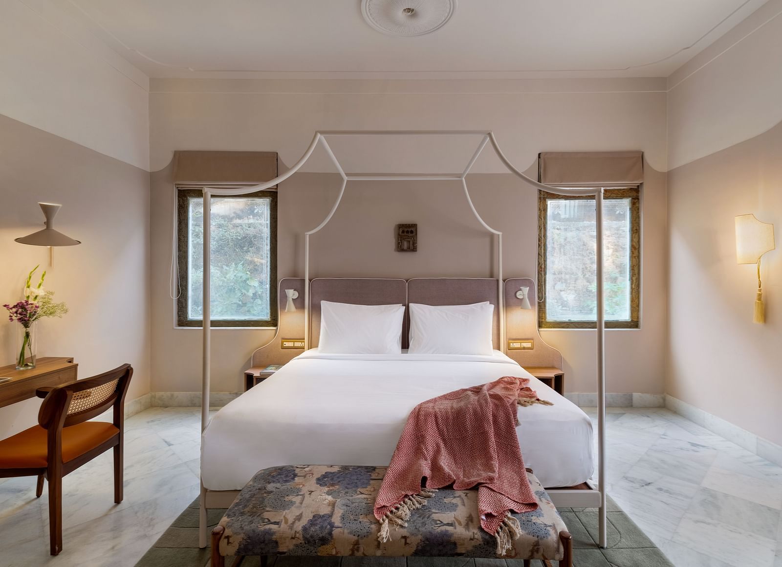 A double bed with a study table next to it inside Superior Room - Manuscript - Jhilwara Haveli, Udiapur