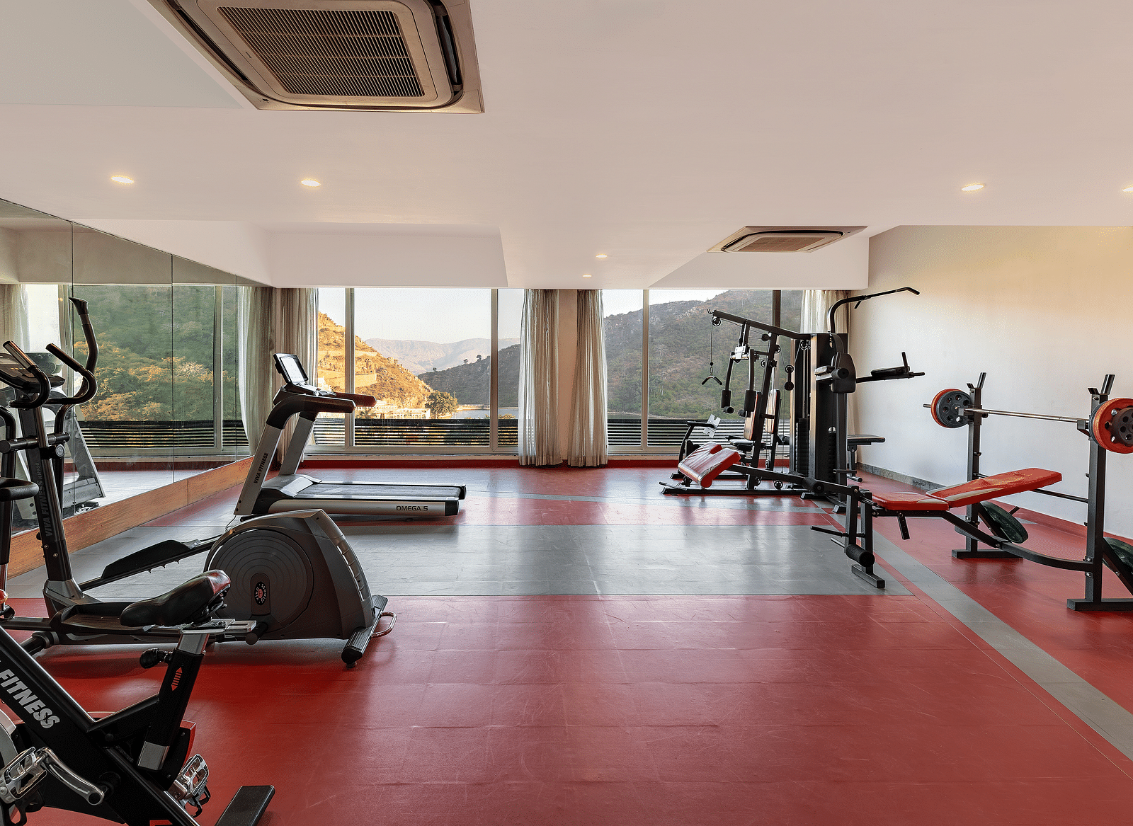 A gym neatly arranged with exercise equipment - Via Lakhela Resort & Spa