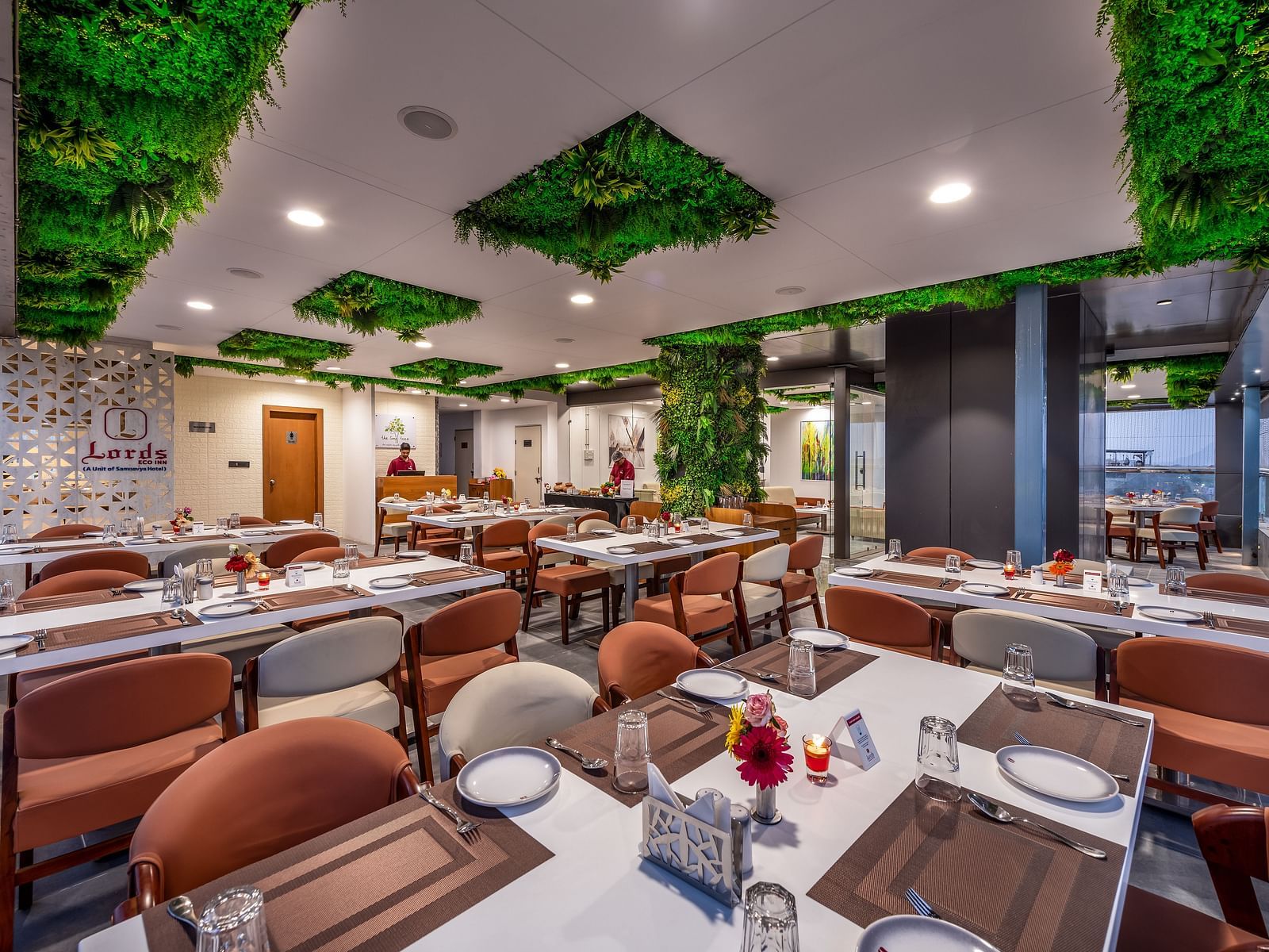A spacious lime tree rooftop restaurant interior with earth-toned seating and lush ceiling decor.