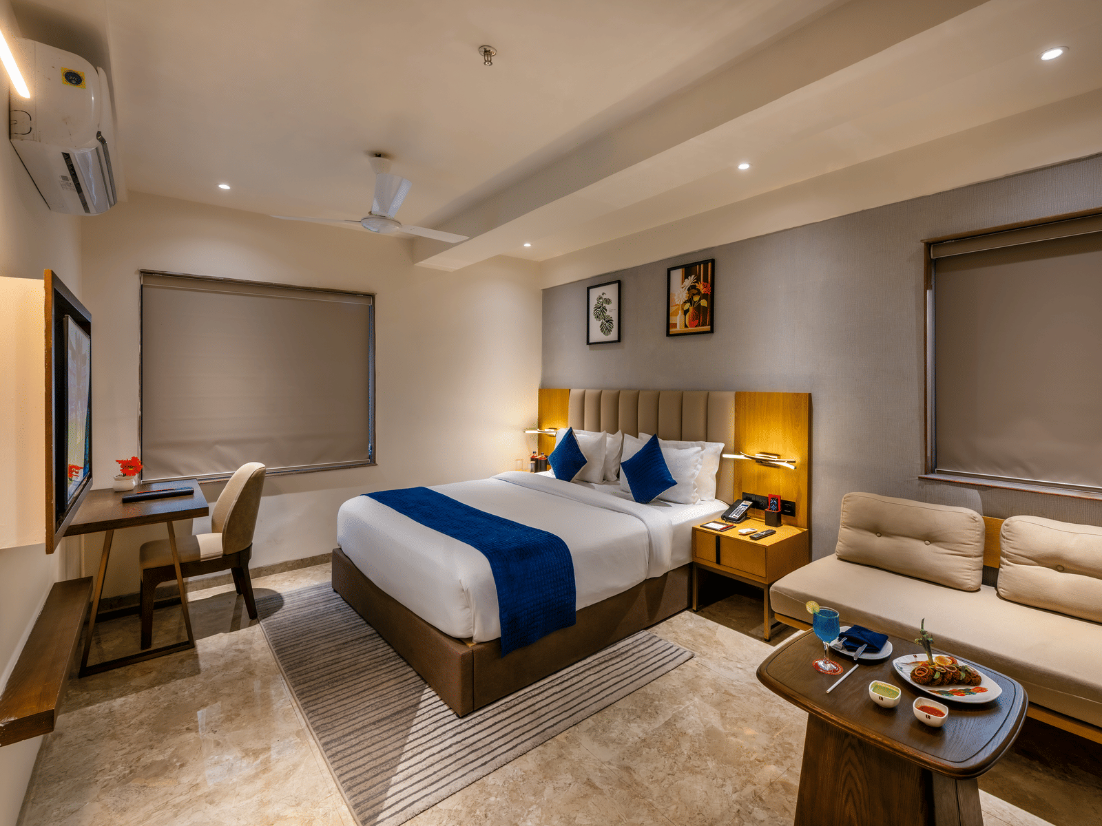 Spacious interior with king bed, seating area, and modern décor at Lords Studio Inn, Jamnagar.