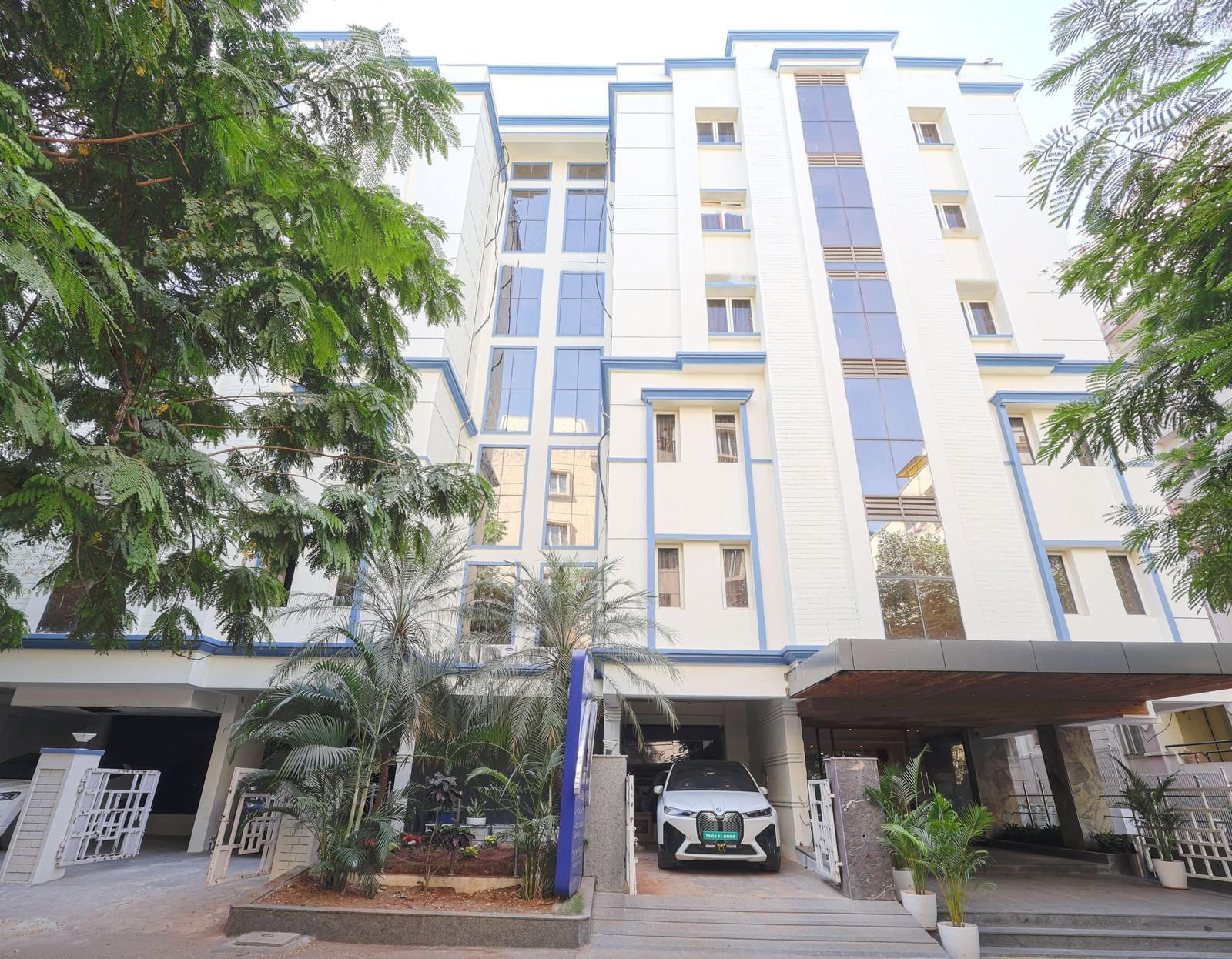 The exterior view of the Monday Hotels HITEC City, Hyderabad building surrounded by greenery.