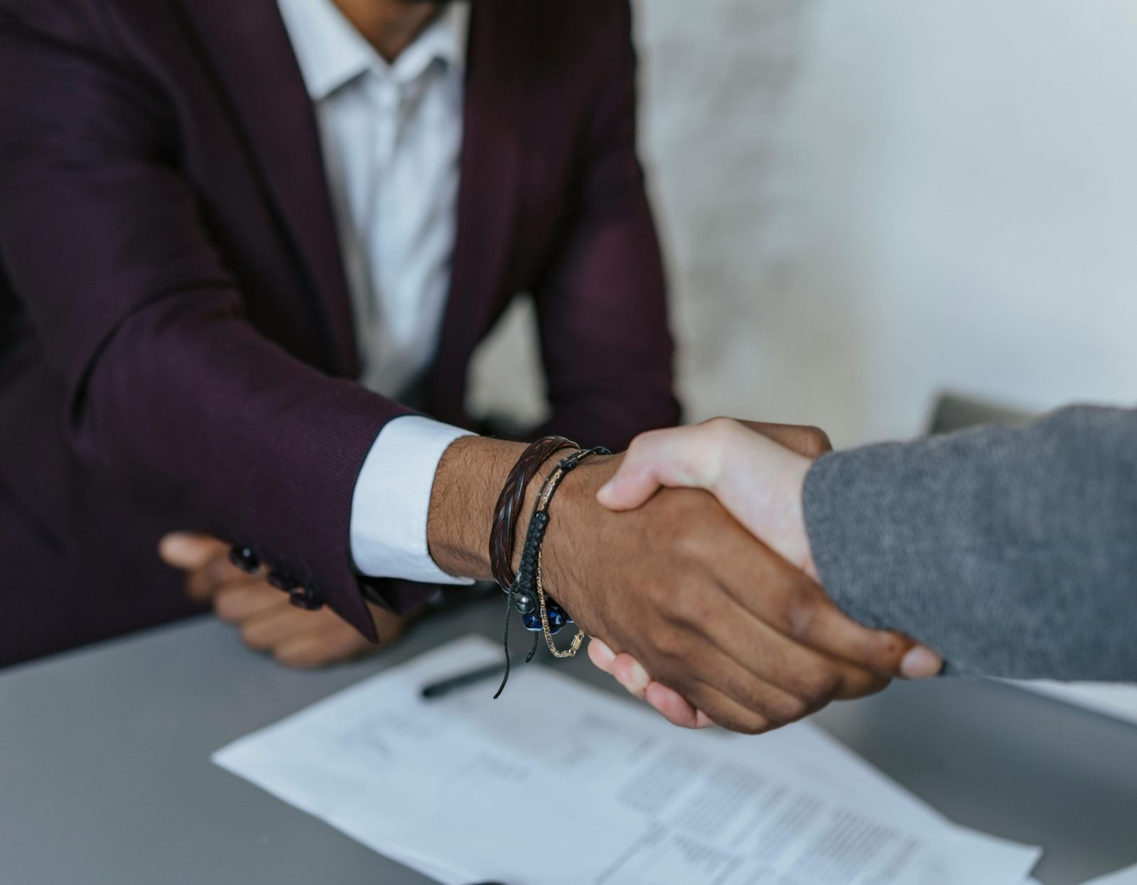 A close-up shot of 2 people shaking their hands together.