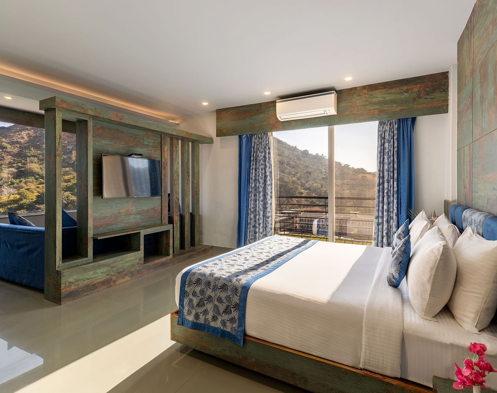A bedroom with a made bed, patterned runner and a mountain view through the window - Via Lakhela Resort & Spa 