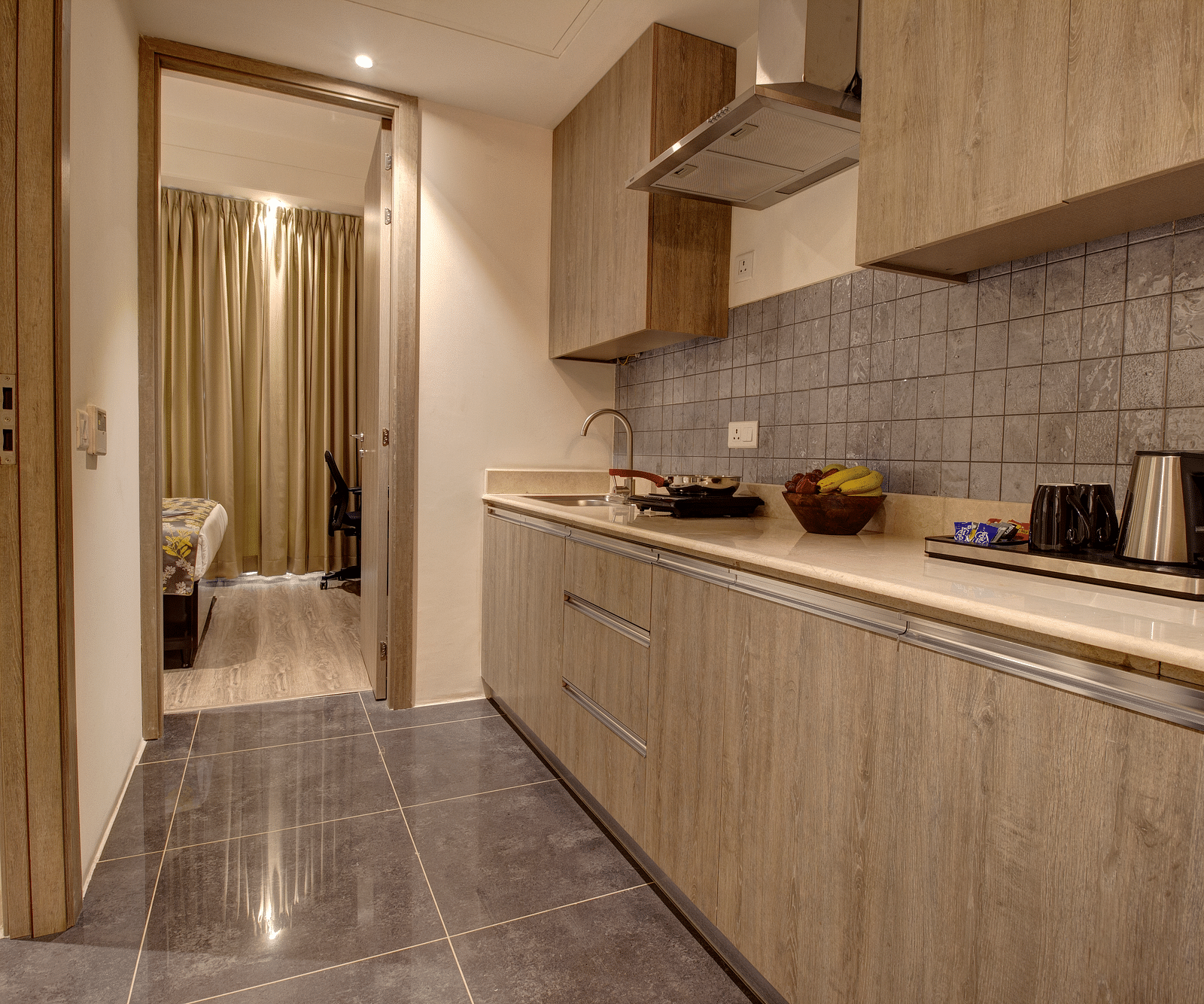 Overview of the Kitchenette with an electric stove and a kettle kept on the counter inside the deluxe room - Rhythm Gurugram