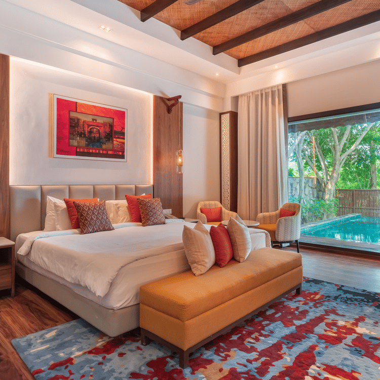 A king size bed with ottoman and a large floor to window ceiling at Ananta Villa - The Ananta Udaipur