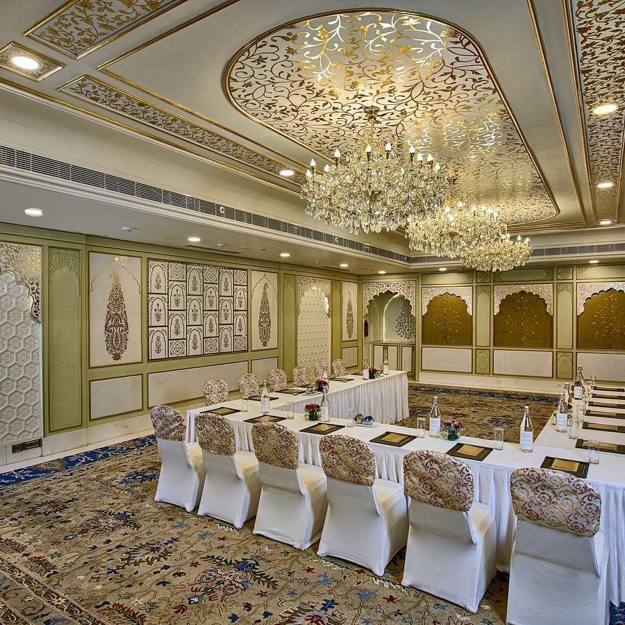 A luxurious banquet hall with ornate gold-accented walls, a patterned ceiling, and sparkling chandeliers - Heritage Village Resorts & Spa, Manesar