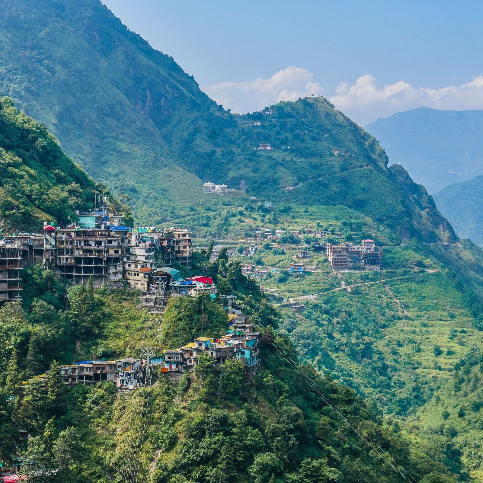 Sub-aerial view of a mountain town on a sunny day surrounded by lush greenery